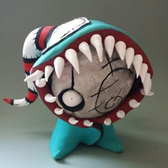 an odd looking toy with sharp teeth on it's face and mouth is painted red, white, and blue