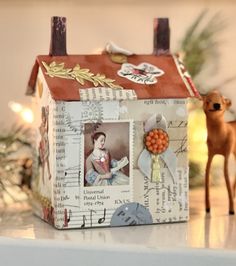 a small doll house sitting on top of a table next to a deer figurine