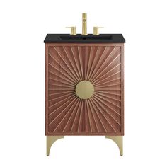 an art deco bathroom vanity with black counter top and gold accents on the front, along with two brass faucets