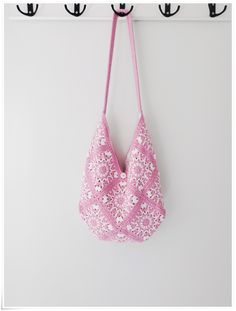 a pink bra hanging from a hook on a wall