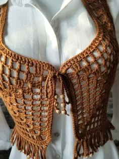 a crocheted shawl is shown on a mannequin's torso