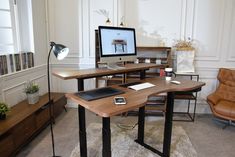 a desk with a computer monitor, keyboard and mouse on it next to a brown leather chair