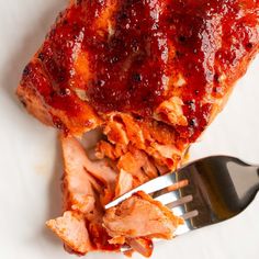 a piece of meat with ketchup on it and a fork next to it