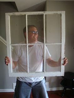 a man holding up a window in front of his face