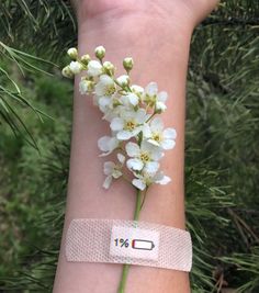 a wristband with flowers on it is attached to a woman's arm in the woods