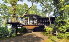 the house is surrounded by trees and has two decks on each level that are connected to one another