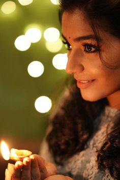 a woman holding a lit candle in her hand