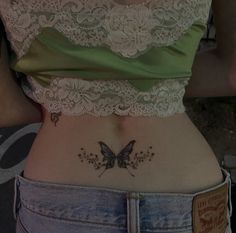 a woman's stomach with a butterfly tattoo on her lower back and the bottom part of her waist