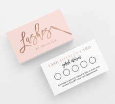 two business cards sitting next to each other on top of a white surface with gold lettering