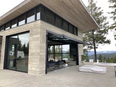 a modern house with large glass windows overlooking the mountains