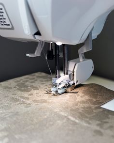 the sewing machine is being used to sew something on it's surface,