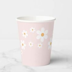 a pink paper cup with daisies on it