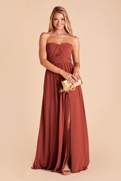 a woman in a strapless red dress holding a gold clutch and posing for the camera