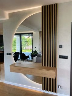 an open living room and dining area with wood accents on the walls, along with modern furniture