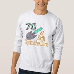 a man wearing a white sweatshirt with the words 70 and fish in the dirt on it