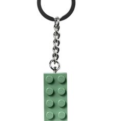 a green lego keychain with a black rubber ring hanging from it's side