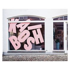 a store front with pink graffiti on the windows