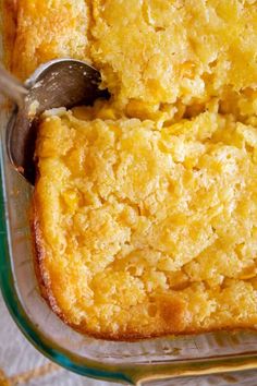 a casserole dish filled with cornbread and topped with a serving utensil