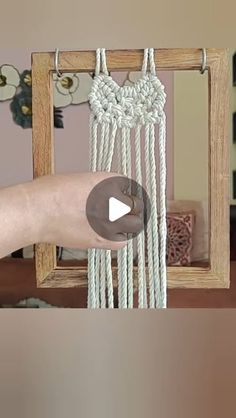 a person is holding up a white macrame