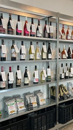 bottles of wine are lined up on shelves in a liquor store with labels attached to them