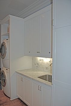 a washer and dryer in a white laundry room