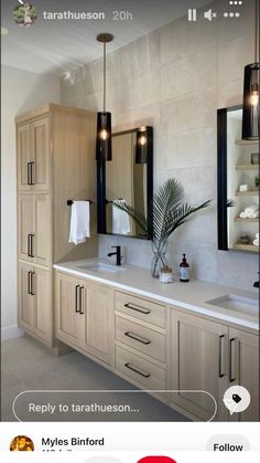 a large bathroom with two sinks and mirrors on the wall next to it's cabinets