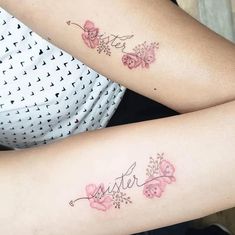 two women with matching tattoos on their arms, both have pink flowers and the word sister written in cursive writing