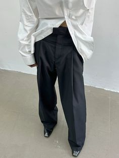 a man in white shirt and black pants with his back turned to the camera,