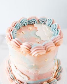 a multi - layered cake decorated with pastel icing and sprinkles