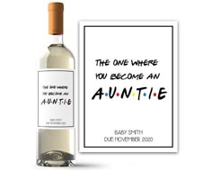 a bottle of wine next to a card with the words,'the one where you become an auntie '