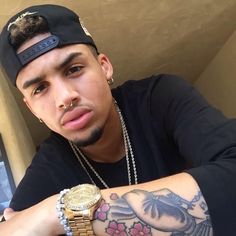 a man with tattoos and a watch on his arm