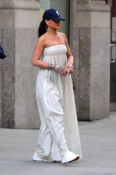 a woman in a strapless dress walking down the street