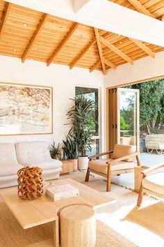 a living room filled with furniture and a wooden ceiling mounted to the side of a wall