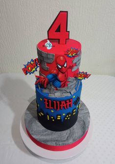 a birthday cake with the number four on it and spiderman decorations around the top