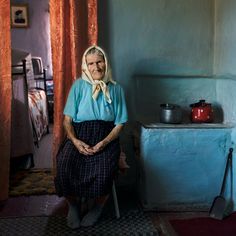 an old woman sitting on a chair in a room