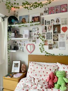 there is a bed with many pictures on the wall and a teddy bear sitting on it