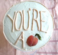 a white cake with the words you're a peach on it and an apple