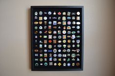 a black framed wall hanging with many different badges and emblems on it's side