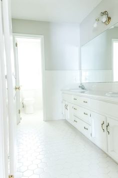 a white bathroom with two sinks and mirrors