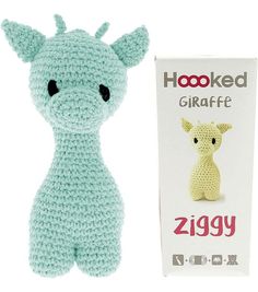 a crocheted blue stuffed animal next to a box of hooked giraffe