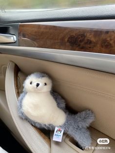 a stuffed animal sitting in the center console of a car, with a sticker on it