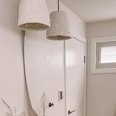 a bathroom with a surfboard on the wall and two lights hanging from the ceiling