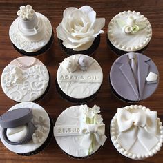 wedding cupcakes decorated with white and gray icing on a wooden table top