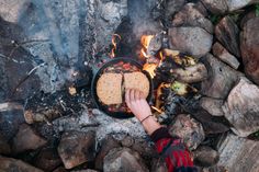 a person is cooking food over an open fire