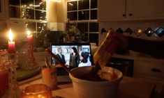 a table topped with a bowl filled with food and candles