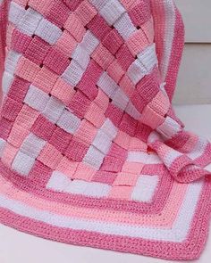 a pink and white blanket sitting on top of a table