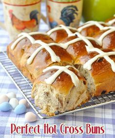 hot cross buns with white icing on a cooling rack