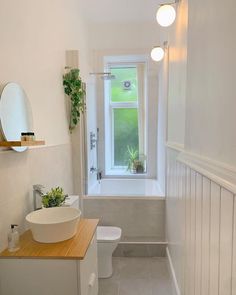 a bathroom with a sink, toilet and bathtub next to a window in the wall