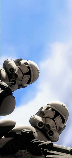 two star wars stormtroopers sit on top of each other in front of a blue sky