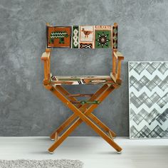 a wooden chair sitting in front of a gray wall